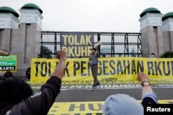 Seorang aktivis meneriakkan slogan-slogan dalam aksi protes menolak RKUHP di luar gedung DPR RI di Jakarta, 5 Desember 2022. REUTERS/Willy Kurniawan