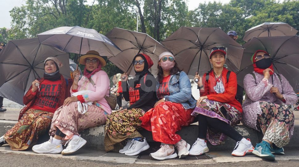Sejumlah Ibu Pekerja Rumah Tangga (PRT) melakukan aksi Rabuan PRT: Payung Duka Seribu Ibu-Ibu PRT Indonesia di Taman Aspirasi Monas, Jakarta Pusat, Rabu (21/12/2022). [Suara.com/Alfian Winanto]