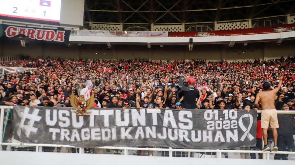 Suporter Indonesia membentangkan spanduk terkait Tragedi Kanjuruhan saat pertandingan sepak bola Grup A Piala AFF 2022 antara Indonesia dan Kamboja di Stadion Utama Gelora Bung Karno (SUGBK), Jakarta Pusat, Jumat (23/12/2022). [Suara.com/Alfian Winanto]